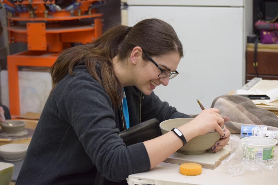 ents member working on their clay bowl